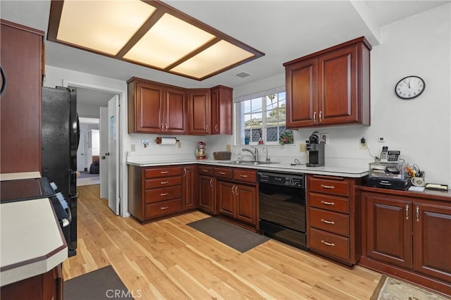 kitchen with visible vents, dishwasher, light countertops, light wood-style flooring, and a sink