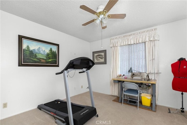 exercise area featuring a textured ceiling, ceiling fan, and carpet flooring