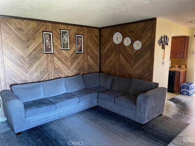 living area with wooden walls and a textured ceiling