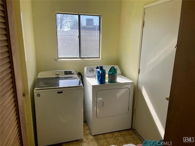 laundry area with laundry area, separate washer and dryer, and light floors