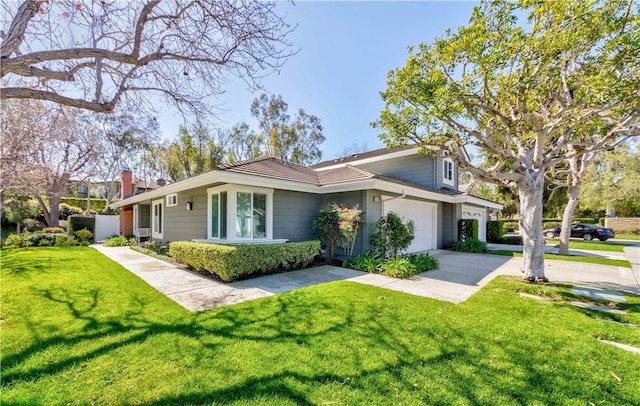 view of side of home with a yard, a garage, and concrete driveway