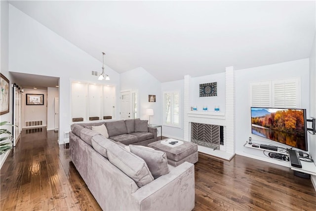 living room with visible vents, high vaulted ceiling, a brick fireplace, and dark wood-style floors