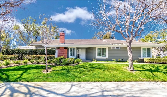 single story home featuring a chimney and a front yard