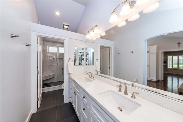 full bath featuring double vanity, a stall shower, lofted ceiling, and a sink