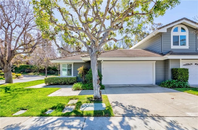 view of front of property featuring a front yard, an attached garage, driveway, and a tile roof