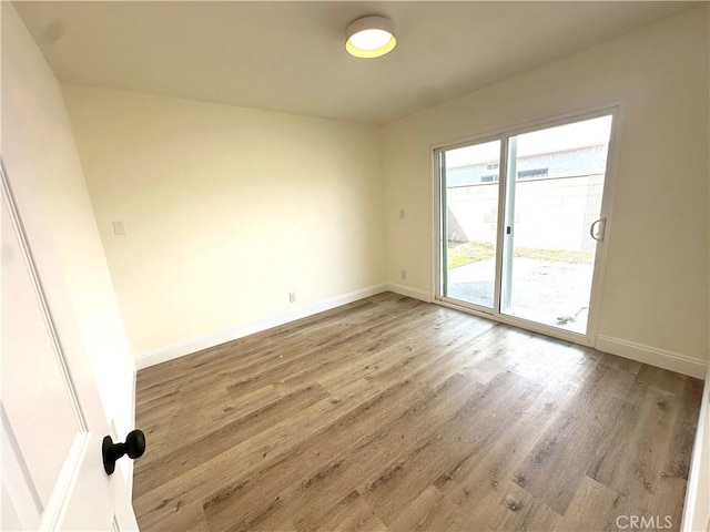 empty room with baseboards and light wood finished floors