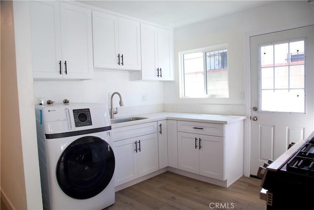 laundry room with light wood finished floors, washer / dryer, and a sink