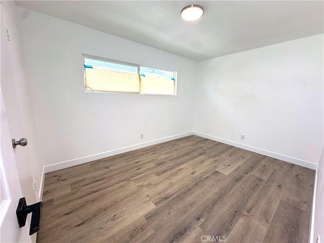 empty room with baseboards and wood finished floors