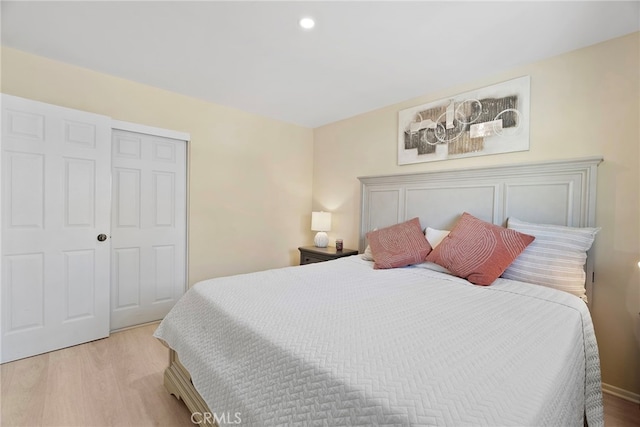 bedroom with a closet, recessed lighting, and light wood-style floors