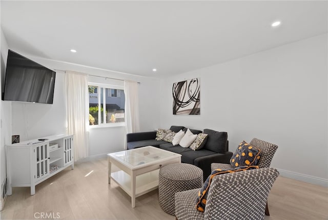 living room with recessed lighting, light wood-style floors, and baseboards