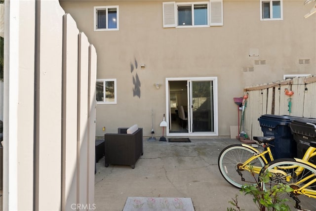 rear view of house featuring a patio and stucco siding