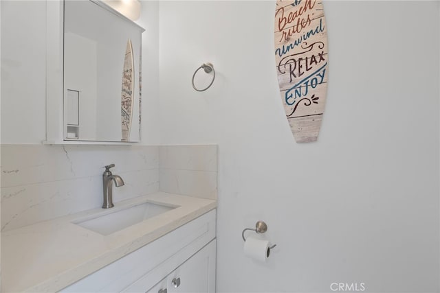 bathroom featuring vanity and tasteful backsplash