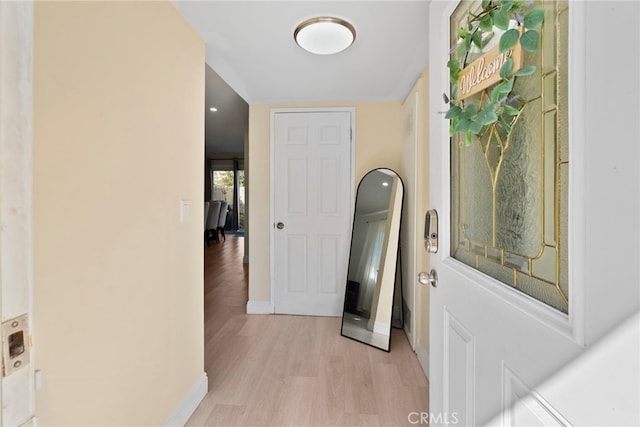 hallway featuring light wood-type flooring and baseboards