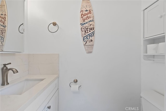 half bathroom with tasteful backsplash, toilet, and vanity