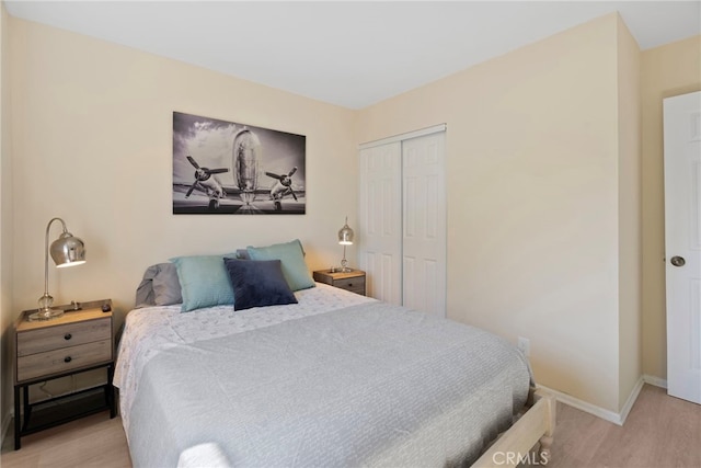 bedroom featuring wood finished floors, baseboards, and a closet