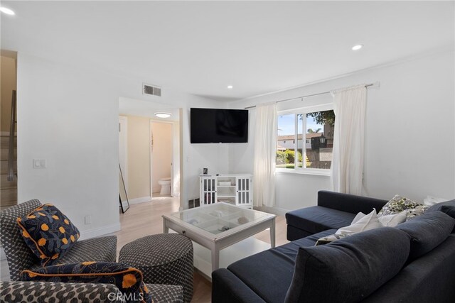 living area featuring visible vents, recessed lighting, baseboards, and light wood-style floors