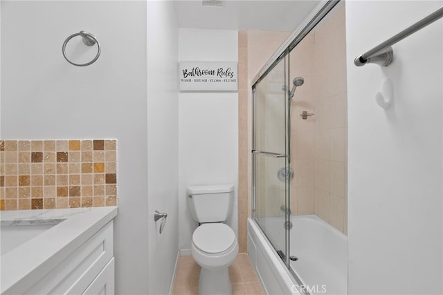 full bath featuring vanity, tile patterned floors, toilet, and bath / shower combo with glass door