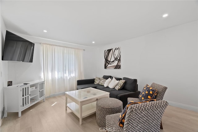 living area with light wood-style flooring, recessed lighting, and baseboards