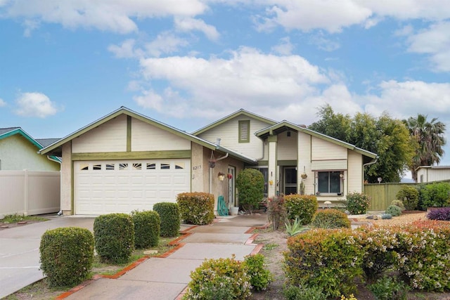 view of front of property featuring driveway, an attached garage, and fence