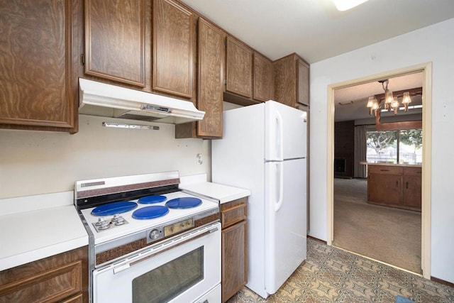 kitchen with white appliances, light countertops, under cabinet range hood, light carpet, and a notable chandelier