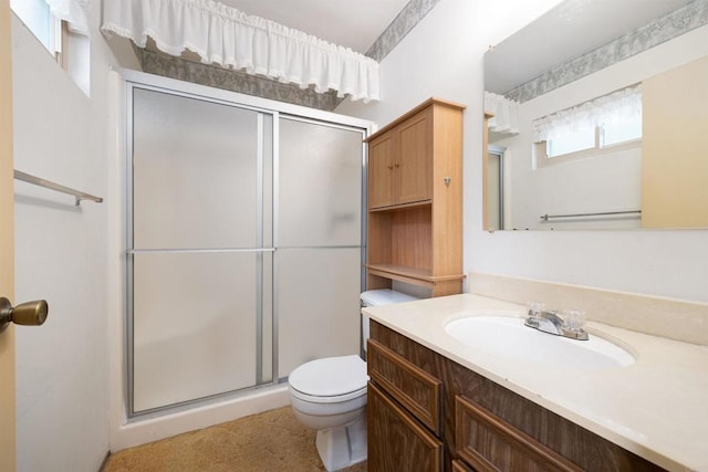 bathroom with vanity, toilet, and a shower stall