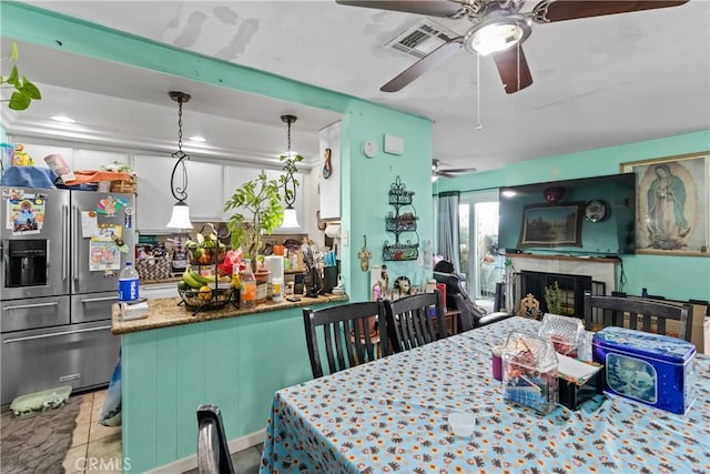 dining space featuring a fireplace and visible vents