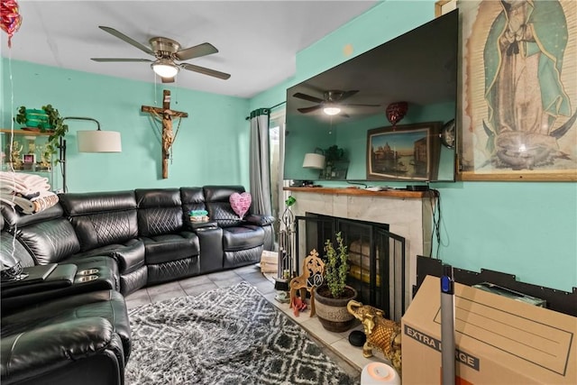 living area featuring tile patterned floors, a ceiling fan, and a high end fireplace