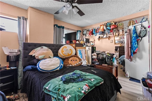 bedroom featuring a textured ceiling, light wood-type flooring, and ceiling fan