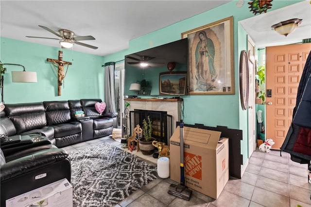 tiled living area featuring a fireplace and a ceiling fan