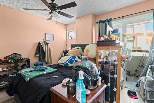 bedroom with ceiling fan and a textured ceiling