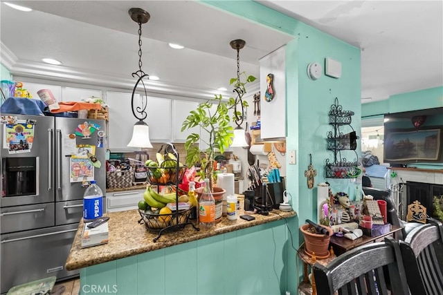 kitchen with a premium fireplace, high quality fridge, a peninsula, and hanging light fixtures