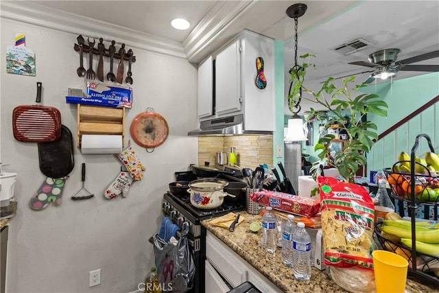 kitchen with tasteful backsplash, visible vents, under cabinet range hood, gas range, and ornamental molding