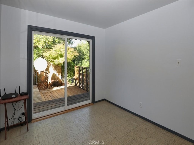 unfurnished room with tile patterned floors and baseboards