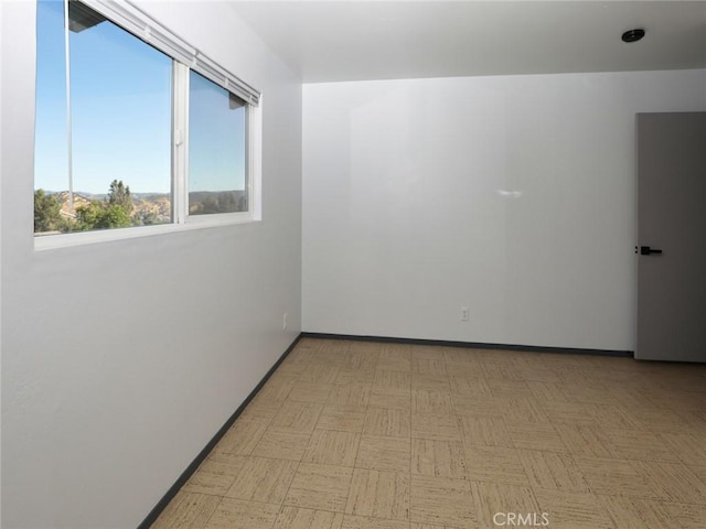 spare room with light floors and baseboards