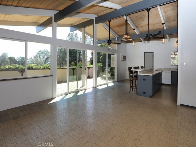 interior space featuring a wealth of natural light, wood ceiling, lofted ceiling with beams, and ceiling fan