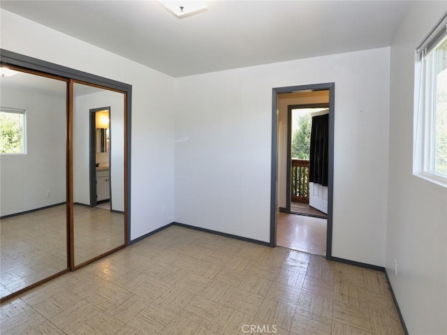 empty room featuring baseboards and a wealth of natural light