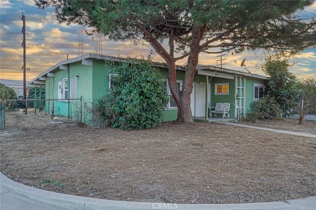 view of front of property featuring stucco siding and fence