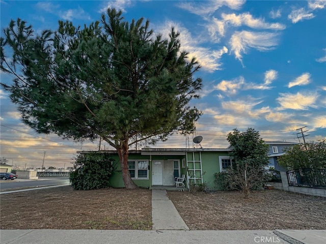 view of front of property featuring stucco siding and fence