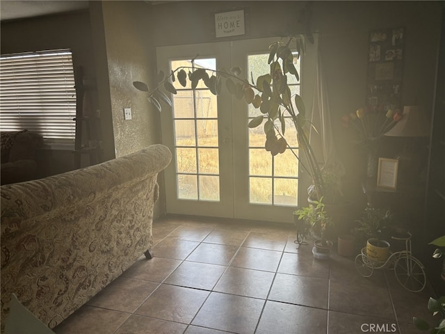 doorway featuring tile patterned floors, french doors, and a textured wall