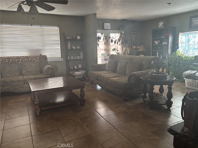 living room featuring tile patterned floors, a textured ceiling, and a ceiling fan