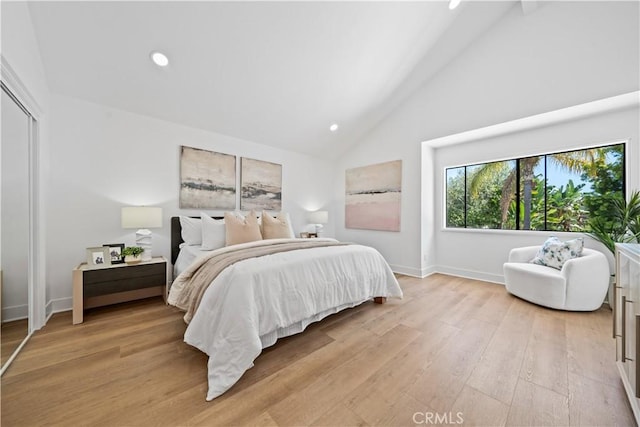 bedroom with recessed lighting, baseboards, light wood finished floors, and high vaulted ceiling