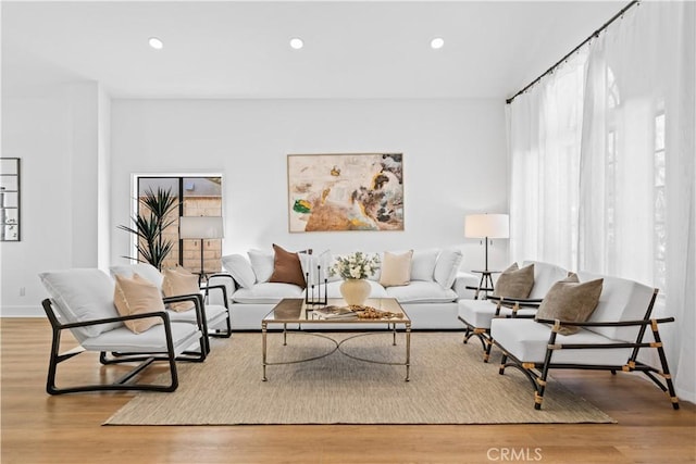 living area with recessed lighting, baseboards, and wood finished floors