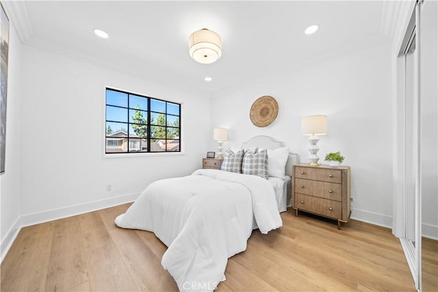 bedroom with recessed lighting, light wood-style flooring, baseboards, and ornamental molding