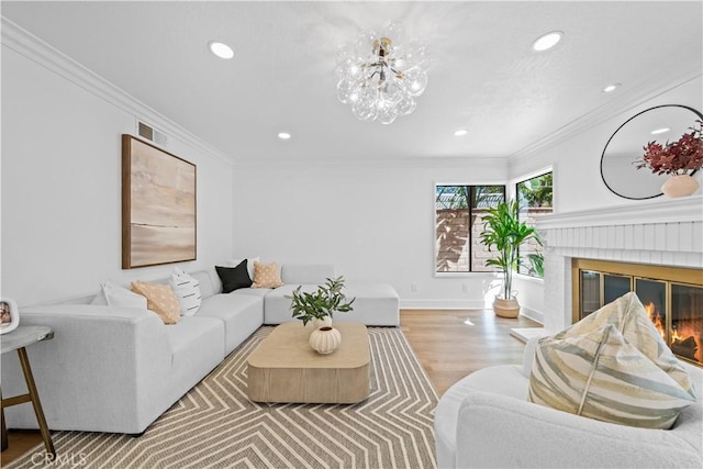 living room featuring visible vents, a brick fireplace, crown molding, baseboards, and wood finished floors