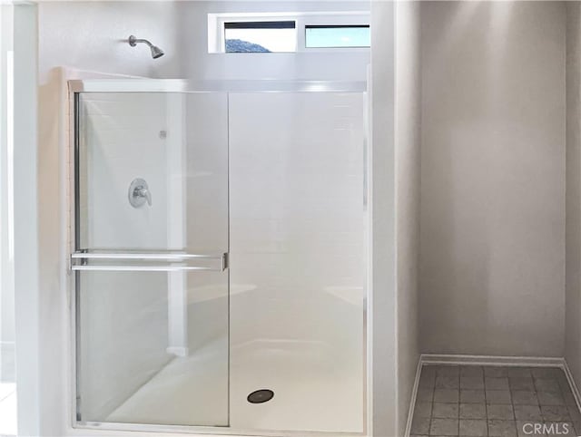 full bath featuring a stall shower and baseboards