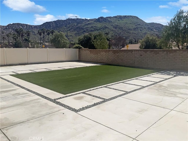 exterior space with a mountain view and a fenced backyard