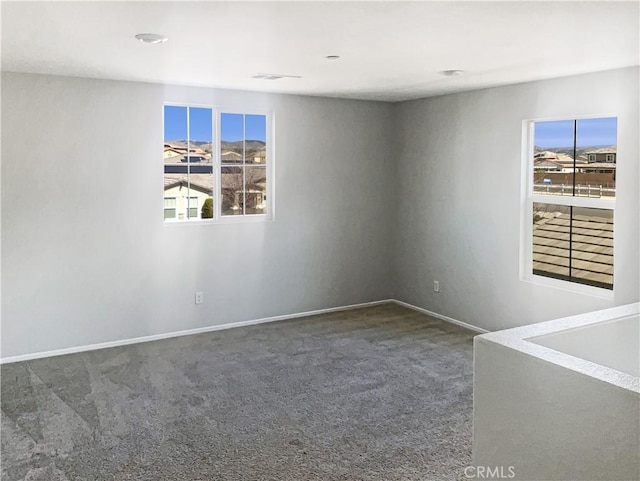 spare room featuring baseboards and carpet