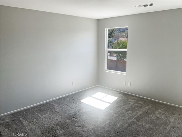 spare room with carpet, visible vents, and baseboards