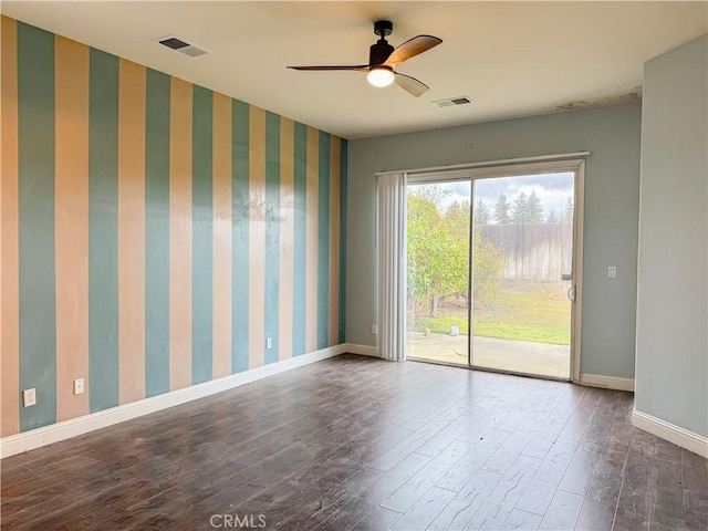 unfurnished room featuring visible vents, wallpapered walls, baseboards, and wood finished floors