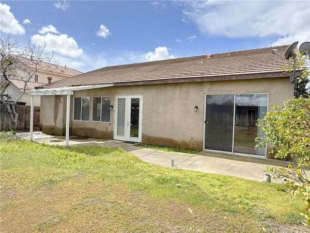 back of house featuring a patio area, a lawn, stucco siding, and fence